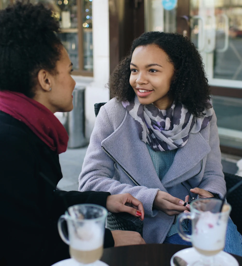 Two women talking at a café table