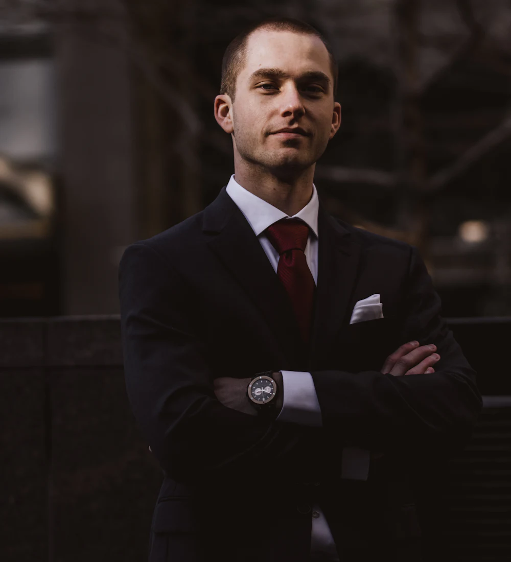 A man standing outdoors in a suit